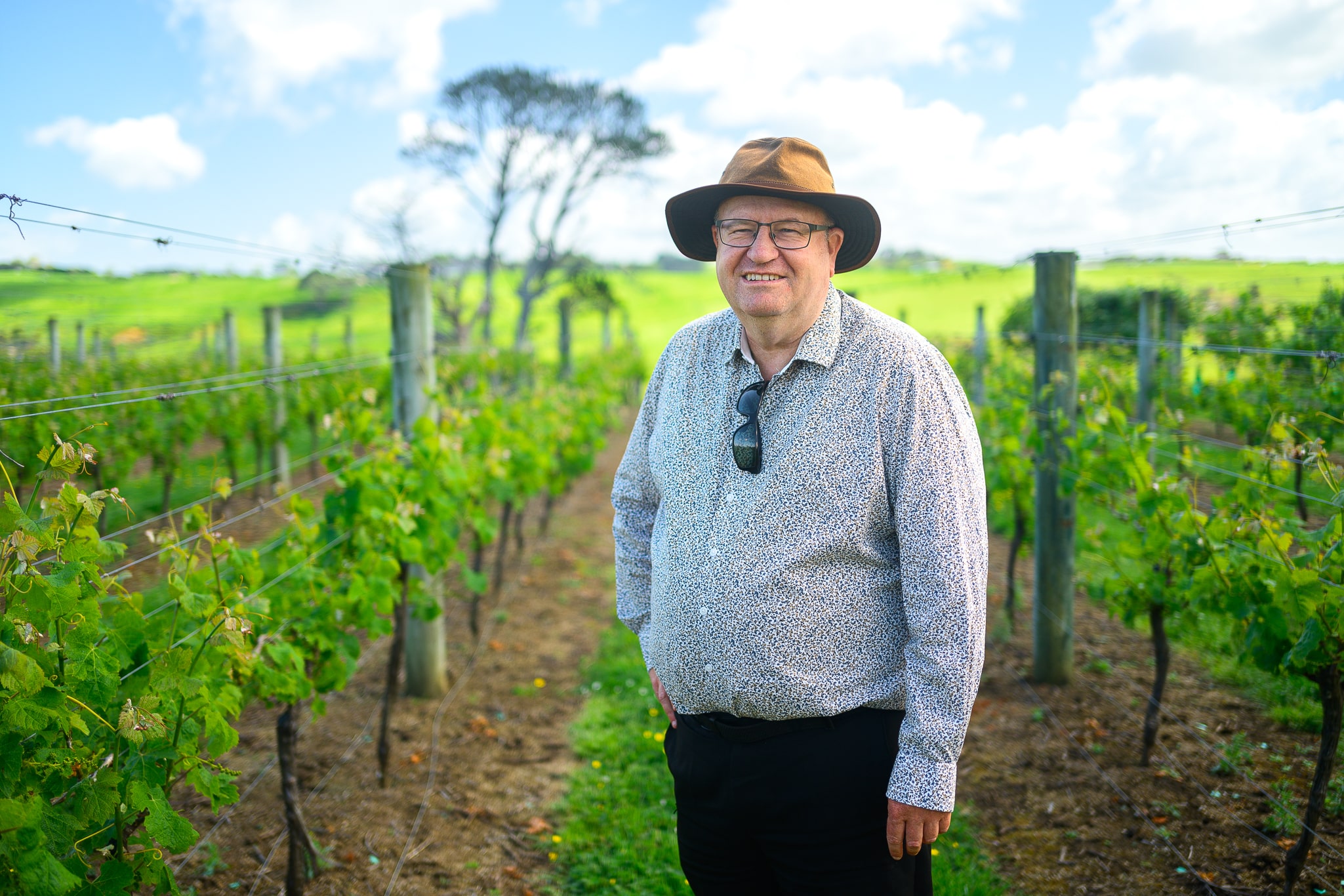Owner standing in front of vineyard